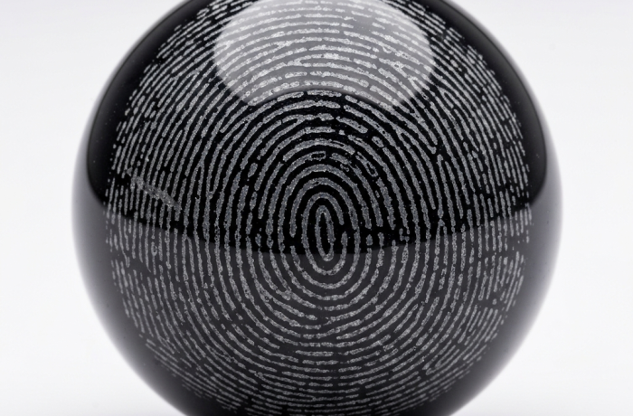 Esfera de vidrio con huella grabada sobre mesa