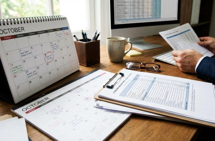 Vista de escritorio con papeles, calendario y monitor: la lista de espera de visas U, en qué año van las visas U